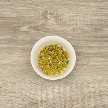 dried chamomile flowers in a white bowl