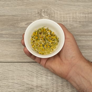 dried chamomile flowers in the hand