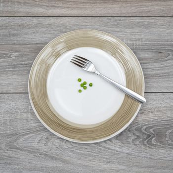 some green peas in a plate on a wooden table