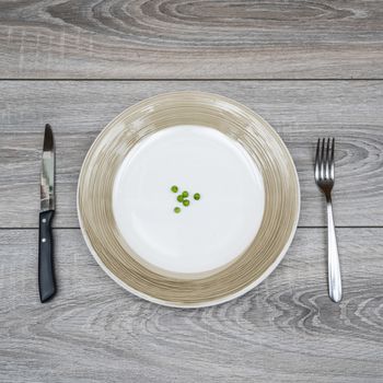 some green peas in a plate on a wooden table