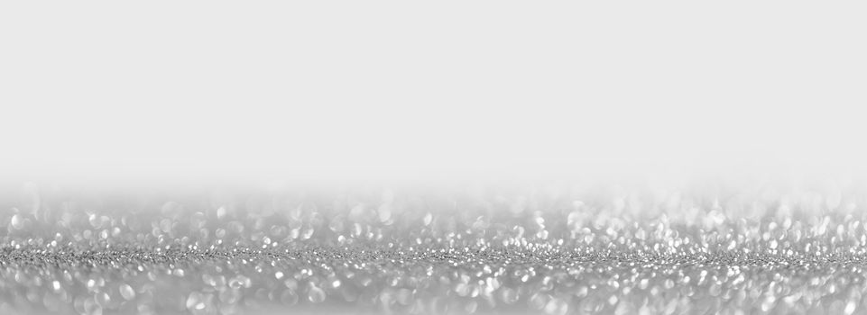 Abstract shining glitters silver on white holiday bokeh background with copy space for text