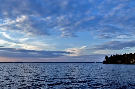 evening lake in cloudy weather, South Ural, Uvildy, in the distance are seen the Ural mountains