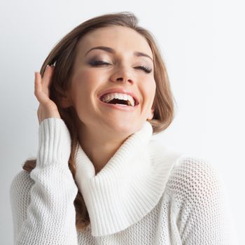 Studio portrait of beautiful long-haired woman in hot sweater on white background