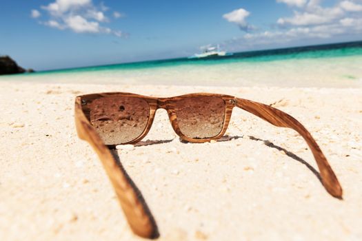 wooden sunglasses lying on the beach
