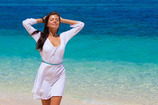 Woman relaxing at the beach enjoying her freedom wear white dress