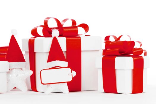 White gift box with red ribbon, stars with santa claus hats isolated on white background