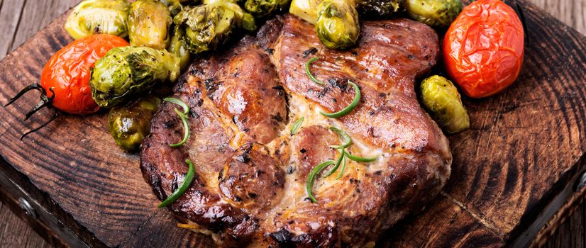 Grilled meat steak with vegetables on the kitchen board. Grilled meat with Brussels sprouts.Long banner