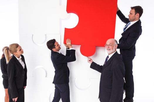 Business team assembling big puzzle isolated on white background