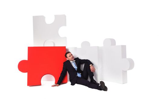 Thinking business man and puzzle isolated on white