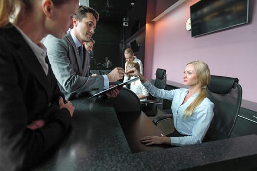 Business people filling forms at reception front desk