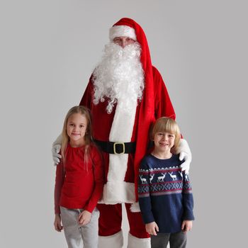 Portrait of Two Children and Santa Claus on gray background