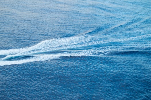 Boat track on the sea, white foam, blue waves, beautiful background.