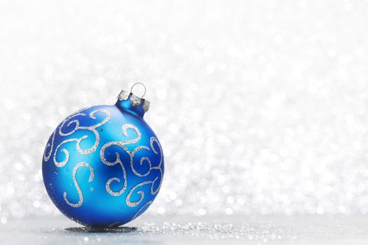 Christmas decorative ball on light silver bokeh background