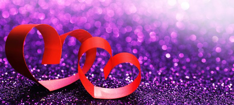 Red ribbon hearts on purple glitters, Valentines day concept