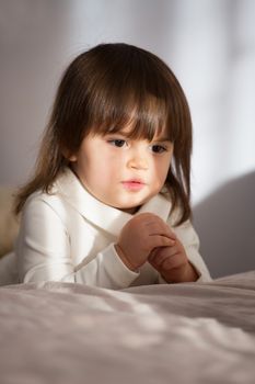Little girl praying in the morning at home . Little caucasian girl hand praying for thank GOD , Hands folded in prayer concept for faith , spirituality and religion
