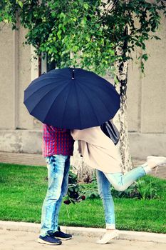 kissing lovers unde an umbrella on a date. photo
