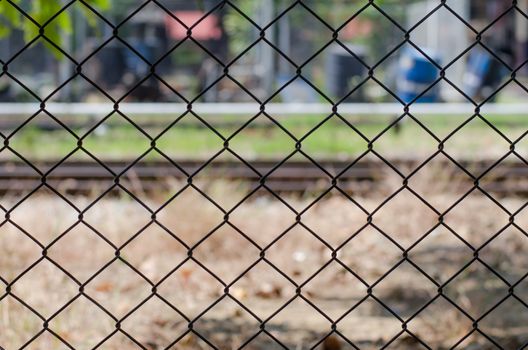 Metal mesh wire fence with blur factory background