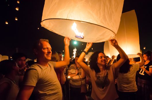 CHIANG MAI THAILAND-OCTOBER 16 : Loy Krathong festival. Unidentified men and women lights floating balloon made of paper annually at the Sansai. on OCT. 25,2014 in Chiang Mai, Thailand.