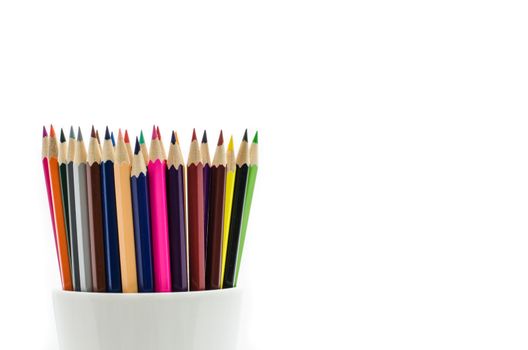 Stack of colored pencils in a glass on white background