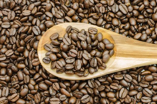 Coffee beans in wooden spoon, close up