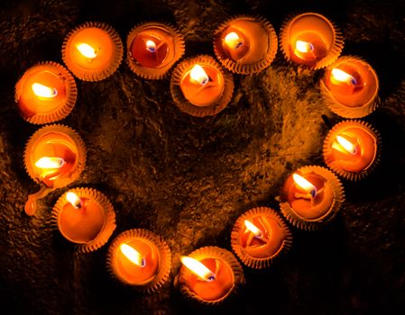 light a candle with heart shaped with floor background