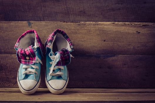 Sneakers on floor on wooden background