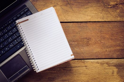 notebook on computer ,on wooden backgrould