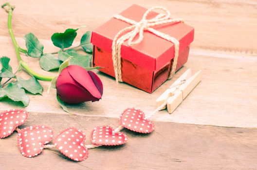 roses and gift box on wooden background