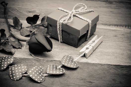 roses and gift box on wooden background