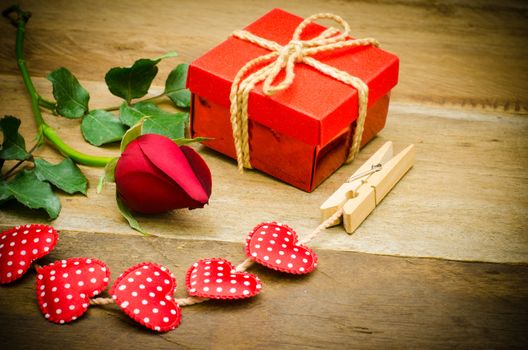 roses and gift box on wooden background