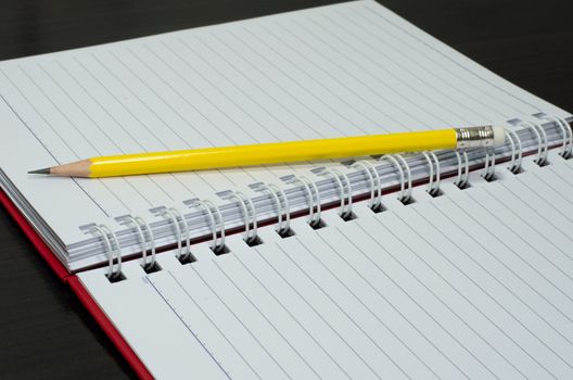 blank notebook with pencil on wooden table