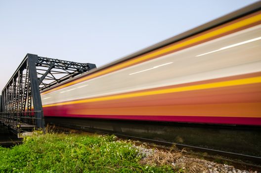 Trains run through the bridge with speed blur.
