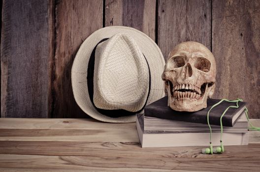 still life - skull on books and hat on wooden table