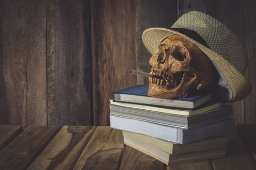 Still life skull . Cap machine weave and books on wooden background