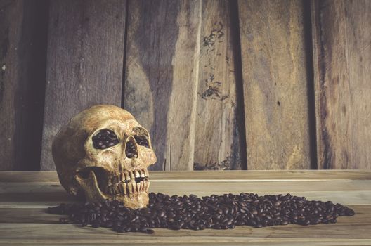 still life skull and bean coffee on wooden background