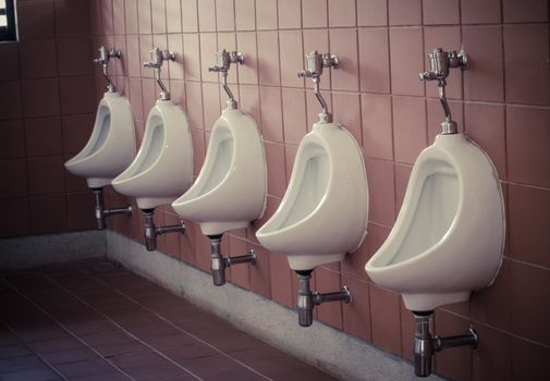 Many urinal in the men's room ,tone vintage