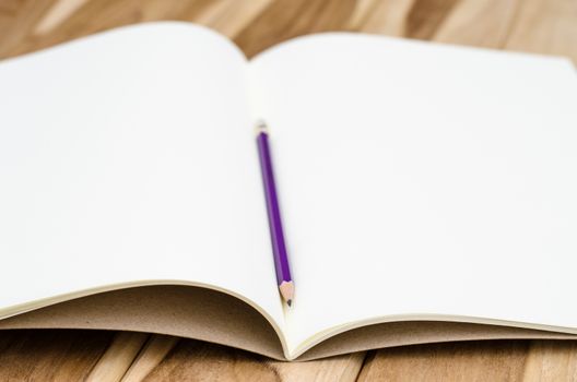 blank notebook with pencil on wooden table - still life