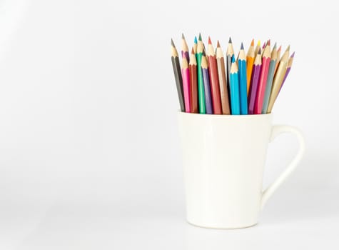 stack of colored pencils in a glass on white background