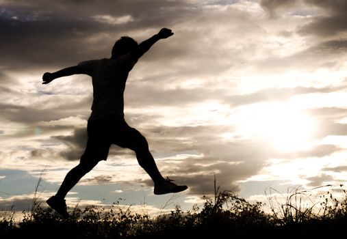 The silhouette of a man exercise on the evening before sunset.