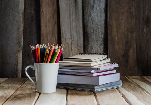 Color pencil and sketchbook on wood table