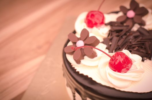 Birthday cake, vanilla Chocolate Cherry was divided pieces on a wooden table.