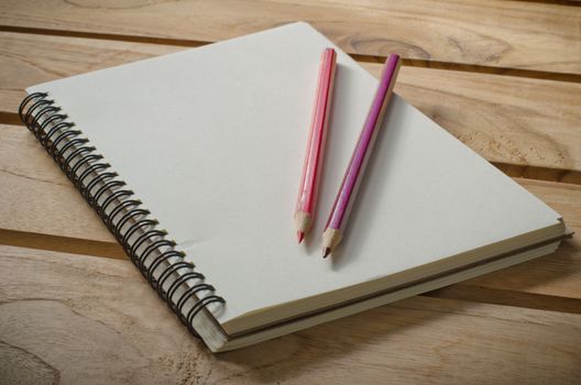 blank notebook with pencil on wooden table - still life