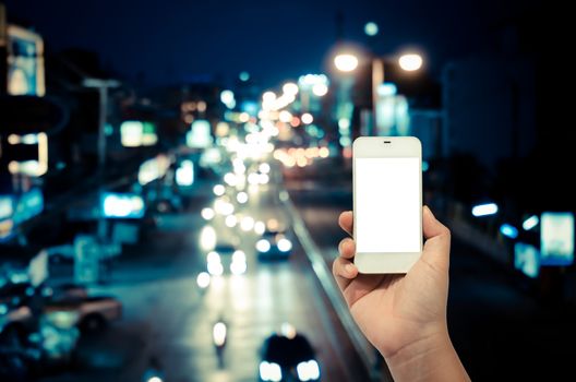 Mobile smart phone behind a blur of traffic.
