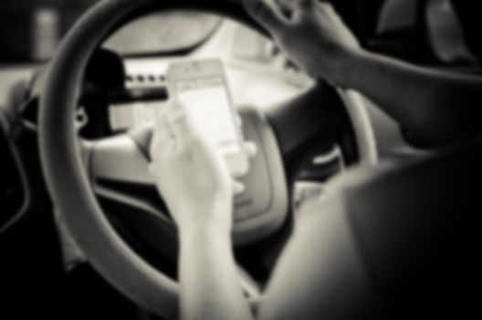Blur images of people using smartphones while driving, safety driving.