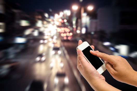Mobile smart phone behind a blur of traffic.