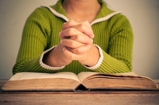 Hands with Bible on wood table