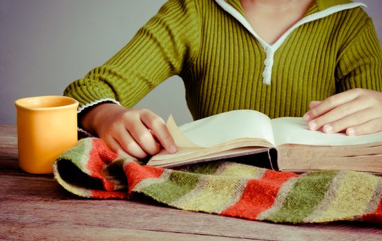 reading book on wooden floor with coffee cup and book