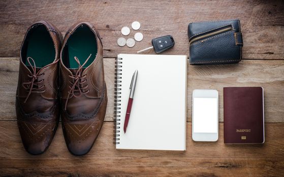 Accessories, passport, wallet and car keys, coins, shoes, notebooks, and pens for the trip.