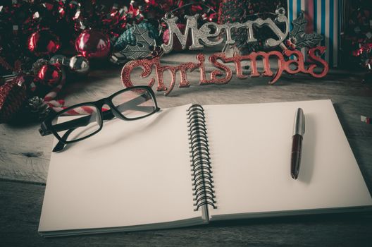 Note pad with pencil on wood desk accessories concept Happy Christmas greeting. through letters,