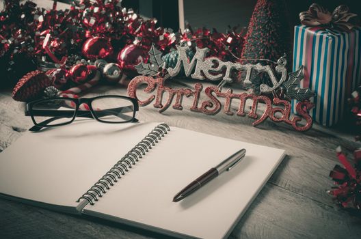 Note pad with pencil on wood desk accessories concept Happy Christmas greeting. through letters,